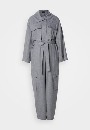 Grau, aus einem Wollgemisch gefertigter Jumpsuit mit kragenförmigem Ausschnitt, zwei Brusttaschen und einem Gürtel in der Taille. Gerade Beinform mit weiterem Ärmel.