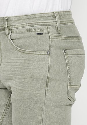 Heledad roheline teksapükste paar, mis on Slim fit stiilis, kerge pleekimisega ja kontrastsest õmblusest. Sisaldab eesmist ja tagumist taskut.