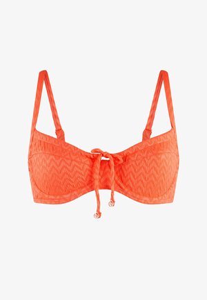 Oranžový bikinový top s texturovaným cik-cak vzorem, se nastavitelnými popruhy a zavazováním vpředu. Doplňky zahrnují malé kulaté kovové prvky.