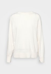 Weißer Pullover mit langen Ärmeln aus weichem Stoff. Verfügt über einen gerippten Saum und Bündchen, mit einem glatten texturierten Körper und einem runden Ausschnitt.