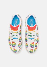 Sneaker bianche con motivi a goccia arcobaleno, presentano un tallone rosso, una soletta blu e lacci bianchi. Texture liscia con perforazioni.