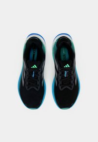 Paire de chaussures de course Adidas noires avec des accents bleus et verts, vue de dessus sur fond blanc.