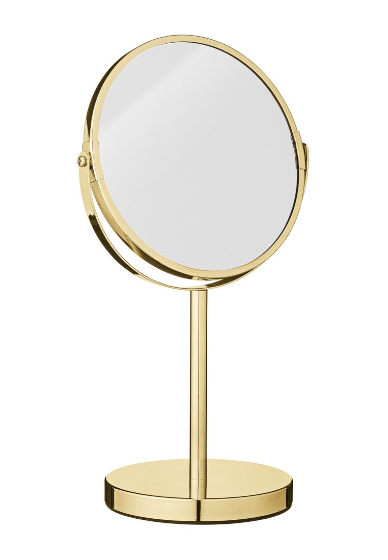 Runder Schminkspiegel mit einem goldenen Metallständer, der eine flache Basis und ein Scharnier für verstellbare Winkel bietet. Reflektierende Oberfläche, minimalistisches Design.