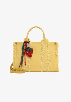 Yellow textured handbag with fringe stripes, short handles, shoulder strap, and a strawberry-shaped charm with red and green cords.