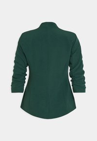 Grön blazer med en strukturerad design, som har långa, samlade ärmar och en skräddarsydd passform, tillverkad av ett slätt tyg med en lätt glans.