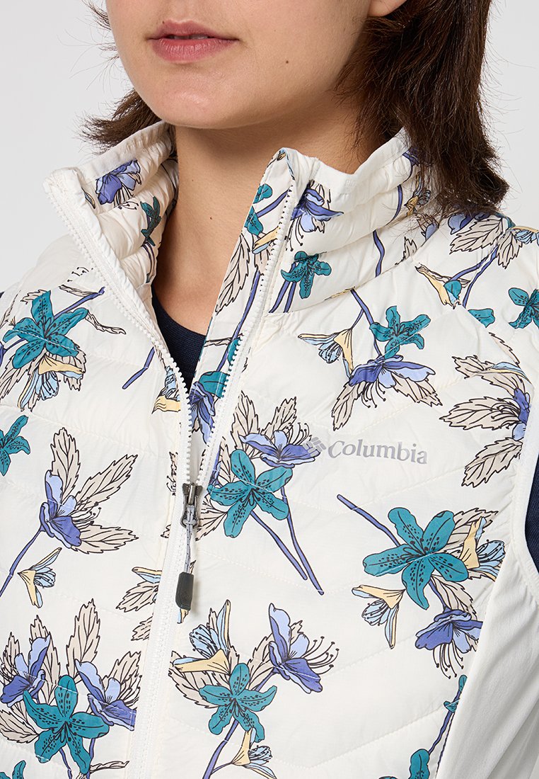 Chaleco tipo puffer blanco con un patrón floral en tonos azules y verdes, con un cuello alto y cierre de cremallera. Logo impreso en el pecho.