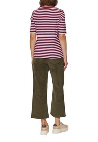 Pasiasty top z krótkim rękawem w kolorze bordowym i białym, w połączeniu z oliwkowymi spodniami szerokimi w nogawkach i beżowymi sneakersami na platformie, widok z tyłu.