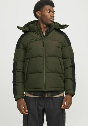 Chaqueta acolchada verde oscuro con cierre de cremallera, acentos negros en los hombros y capucha. Presenta una textura acolchada y puños elásticos.