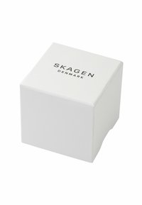 Caja cuadrada blanca con una textura suave, que presenta un diseño minimalista y el nombre de la marca "SKAGEN DENMARK" impreso en negro.