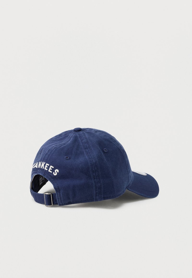 Casquette de baseball bleu marine avec sangle réglable et texte blanc "YANKEES" brodé à l'arrière, présentée sur un fond blanc uni.