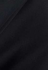 Schwarzer Stoff mit glatter Textur, der subtile Variationen in der Oberflächenbeschaffenheit aufweist und einen leichten Stretch hat, ideal für Bekleidung oder Polstermöbel.