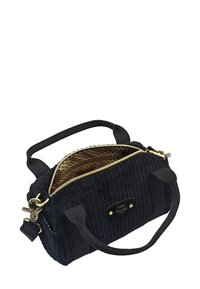 Sac à main en velours côtelé noir avec une fermeture éclair dorée et un intérieur à motifs. Il possède deux poignées et une plaque de marque embossée sur le côté.