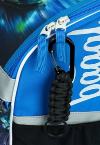 Zaino blu con materiale testurizzato, moschettone nero a contrasto, cordino nero intrecciato e chiusure con cerniera dotate di tiranti blu.