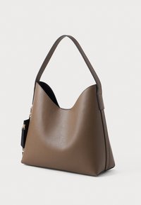 Ruda odinė rankinė su minkštu, tekstūriniu paviršiumi, trikampiu siluetu ir viena plačia rankena. Pridėtas mažas juodas maišelis.