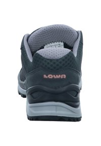Chaussure de randonnée grise avec un dessus en maille et en daim, col rembourré et semelle en caoutchouc. Logo "LOWA" en rose au talon.