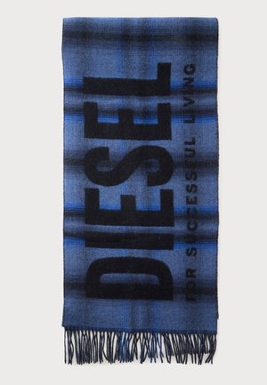 Écharpe à carreaux bleue et noire avec des extrémités à franges et un grand texte noir indiquant "DESER" ainsi qu’un texte plus petit "FOR SUCCESSFUL LIVING" sur un fond uni.