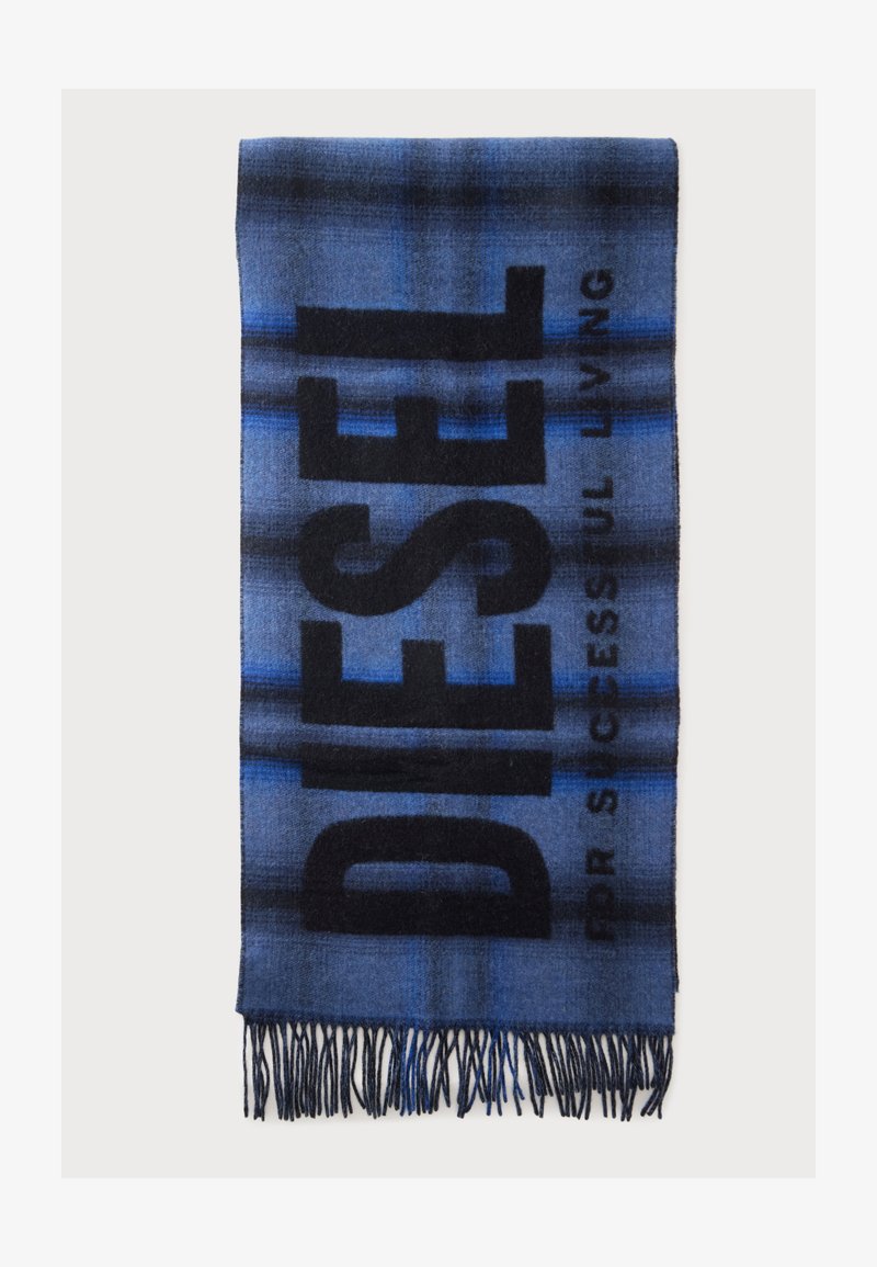 Écharpe à carreaux bleue et noire avec des extrémités à franges et un grand texte noir indiquant "DESER" ainsi qu’un texte plus petit "FOR SUCCESSFUL LIVING" sur un fond uni.