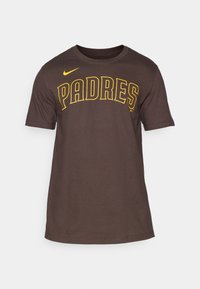 Brun bomulls t-shirt med "PADRES" i fet gul text. Rund halsdesign med korta ärmar, slät textur. Nike-logga på axeln.
