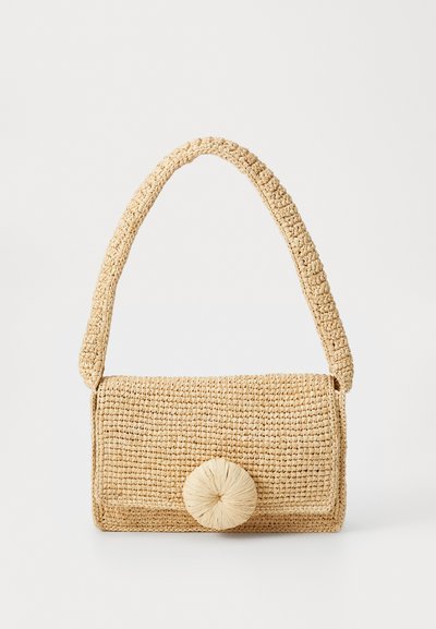 Sac en paille tressée de couleur beige avec un rabat arrondi et une fermeture en pompon circulaire, dotée d'une bandoulière texturée.