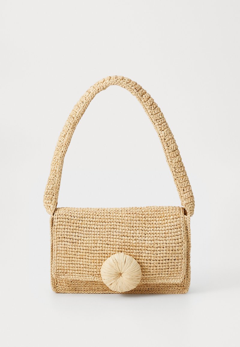 Υφασμένη τσάντα από ψάθα σε μπεζ απόχρωση με στρογγυλή καπάκι και κλείσιμο με κυκλικό πομ-πομ, διαθέτοντας μια υφασμάτινη, υφή ώμου.