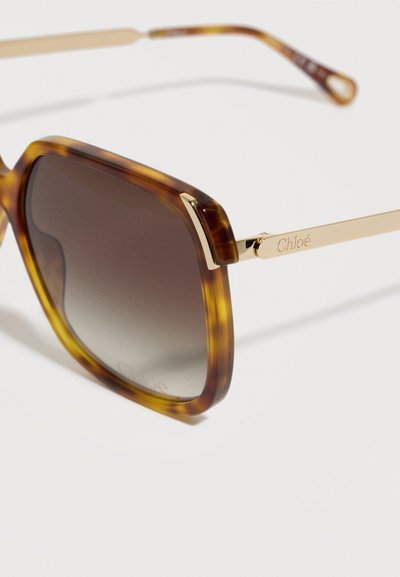Τετράγωνα γυαλιά ηλίου με καβούκι χελώνας και βαθμιδωτούς καφέ φακούς, χρυσά μεταλλικά πλαϊνά με χαραγμένο το λογότυπο "Chloé" στη μία πλευρά.