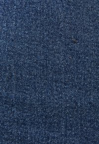 Tessuto denim di un blu indaco intenso con una superficie liscia, caratterizzato da leggere variazioni di tonalità e un motivo a tessitura diagonale.