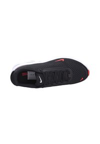 Zapatilla deportiva negra con parte superior de malla, textura perforada, media suela blanca, acentos rojos y sistema de cordones. Presenta un pequeño logo blanco.