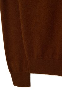 Maglione marrone in maglia caratterizzato da una texture morbida, polsini a costine e un orlo aderente. Il materiale appare caldo e leggero, adatto per essere indossato a strati.