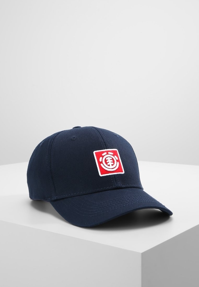 Casquette de baseball bleu marine présentant un logo carré rouge et blanc à l'avant, posée sur une surface blanche avec un fond uni.