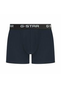 Navy blue cotton boxer shorts with a black elastic waistband featuring white "G-STAR" logo. Smooth texture, mid-thigh length, and fitted design.