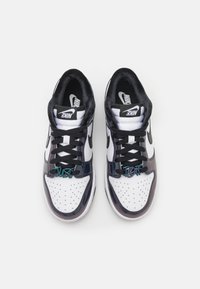 Pair of black and white Nike sneakers with black laces and "Just Do It" lace tags on a white background.