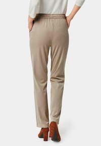 Beige velvet broeken met een elastische tailleband, zijzakken, rechte benen en een zachte textuur, gecombineerd met bruine hoge hakken.