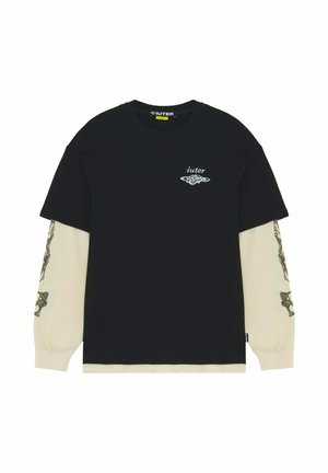 T-shirt nero a maniche corte sovrapposta a maniche lunghe beige con motivi grafici neri e piccolo logo bianco "iuter" sul petto.