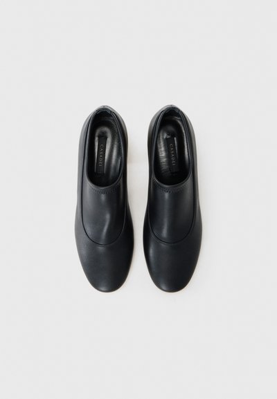 Pantofi negri slip-on din piele netedă, cu un design cu vârf rotunjit și detalii de cusătură minime. Aspect elegant și discret.
