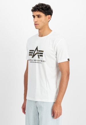 White cotton t-shirt featuring a camo-patterned logo at the chest. Classic fit with short sleeves and a round neckline.