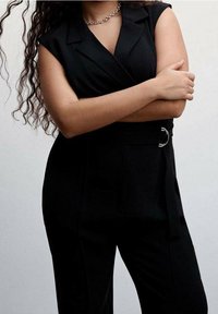 Black tailored jumpsuit with a blazer-style top, short sleeves, and a belted waist. Glossy fabric with smooth texture and no visible patterns.