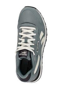 Zapatilla deportiva de color gris claro, fabricada en textil y ante, con detalles en blanco, cordones planos y una suela de goma negra con un patrón texturizado.