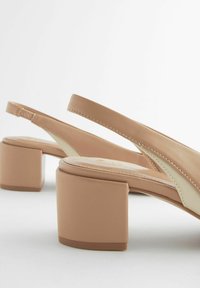 Beige slingback-kengät, joissa on puoliblokki-pohja, silkkinen nahkamateriaali ja vastakohtana off-white-paneeli. Ominaisuuksiin kuuluu minimalistinen muotoilu ja ompelu.