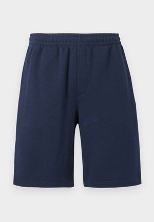 Marineblå elastiske treningsshorts med sidelommer, kne-lang, ensfarget design, vist mot en hvit bakgrunn.