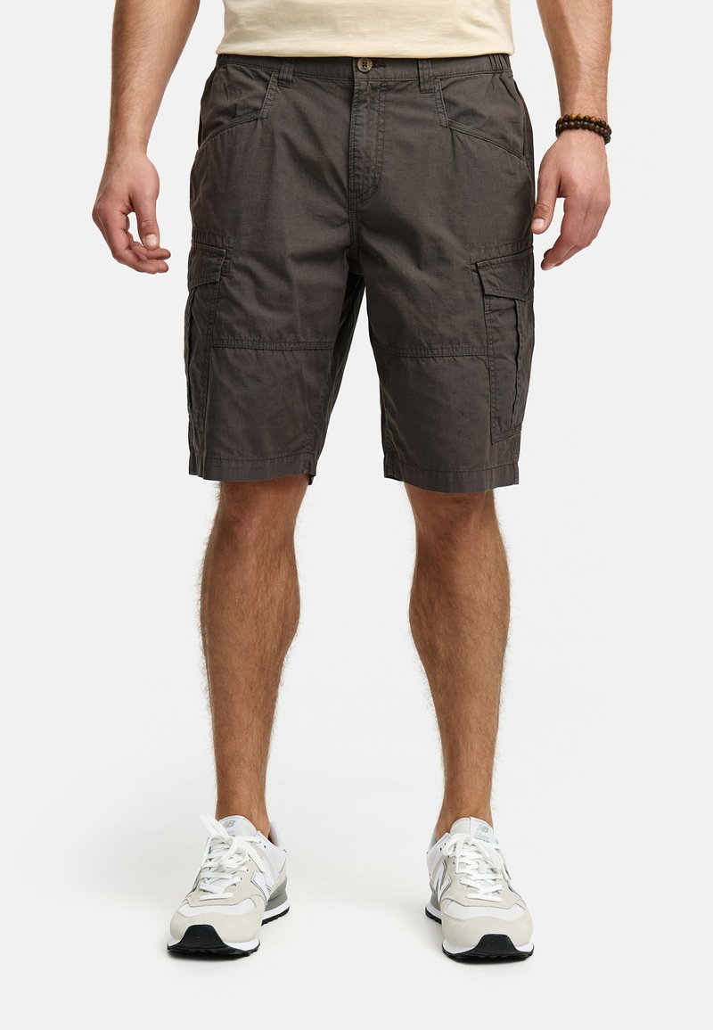 Cargo shorts i mørkegrå stof med sidelommer, knaplukning og en afslappet pasform. Båret med neutrale sportsko.