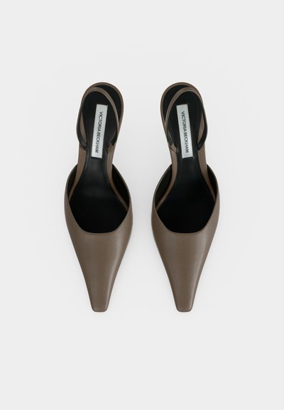 Ζευγάρι καφέ slingback flats με μυτερή μύτη, μαύρες εσωτερικές σόλες και ετικέτες Victoria Beckham σε λευκό φόντο.