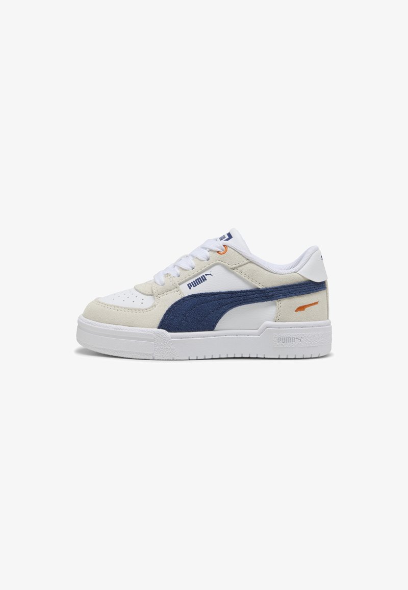 Vita och beige Puma-sneakers med marinblå mockadetalj, orange accent nära hälen, vita snören och texturerad sula på en vit bakgrund.