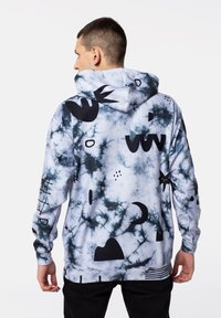 Sudadera con capucha que presenta un patrón de tie-dye en blanco y gris, adornada con varias formas y símbolos abstractos en negro.