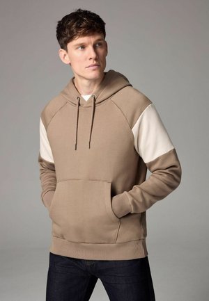 Hooded sweatshirt in light brown with cream raglan sleeves, a front pocket, and a drawstring. Textured fabric, relaxed fit design.