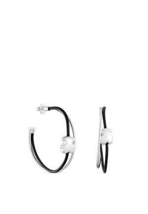 Pendientes de aro de plata con detalles negros y un pequeño colgante pulido de plata con forma de trébol de cuatro hojas en cada aro.