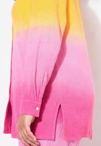 Langærmet skjorte i et gradient design, der går fra gul til pink. Lavet af tekstureret stof med sideslids og knapmanchetter.