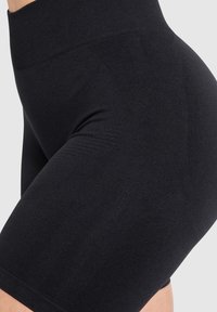 Czarne szorty z wysokim stanem, wykonane z gładkiego, elastycznego materiału. Posiadają dopasowany krój oraz szeroką talię dla wygody.
