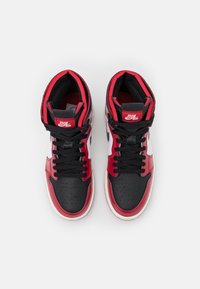 Paire de baskets montantes Nike Zoom Air rouges, noires et blanches avec lacets noirs, vues de dessus sur fond blanc.