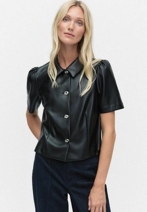 Zwarte faux leren blouse met korte mouwen en een shirtkraag, met een getailleerd ontwerp en glanzende knoopdetails. Glad textuur en subtiele glans.