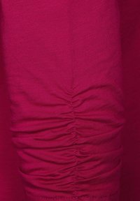 Fuchsia sträcktyg med rynkdekor längs sömmen, med en slät textur och en åtsmitande passform. Lämplig för vardags- eller aktiv klädsel.